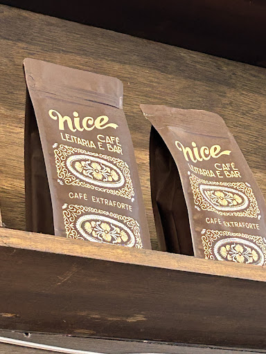 Dois pacotes de café Nice, Café, Leitaria e Bar, café extraforte, em uma prateleira de madeira escura.